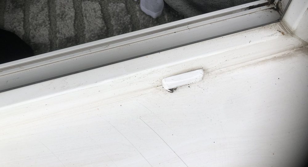Capuchon anti-intempéries blanc sur le trou d'évacuation d'une porte-fenêtre PVC